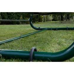 Stelaż huśtawki ogrodowej w kolorze ciemnozielonym, ustawiony na trawie.